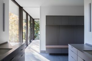 The interior of a modern home with floor to ceiling windows.