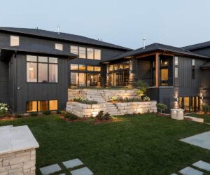 Dark brown home at dusk with sunset reflected in windows and sliding glass doors