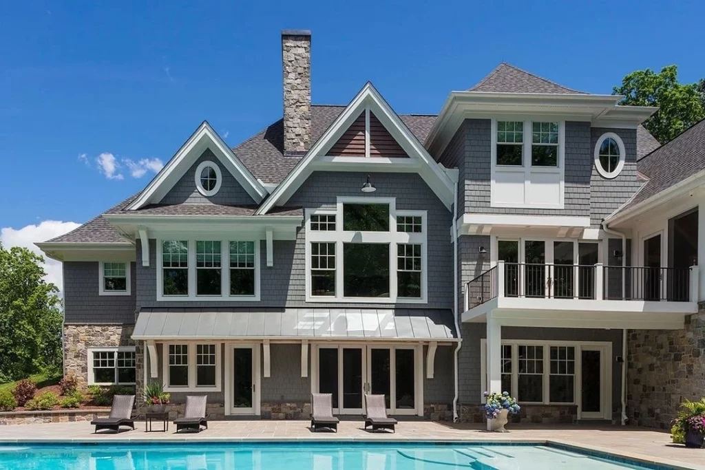 Stately gray multi-level home with expansive glass windows and sliding glass doors